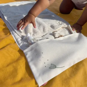 tapis à langer nomade écru naturel en coton bio Pitigaïa vue déplié avec bébé