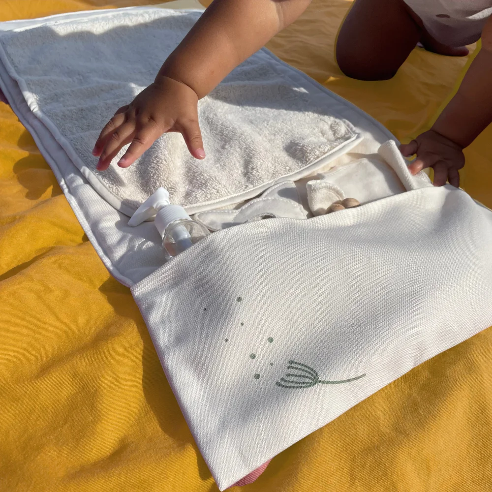 tapis à langer nomade écru naturel en coton bio Pitigaïa vue déplié avec bébé