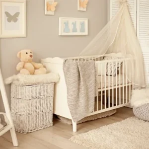 Une chambre de bébé décorée dans un style bohème et naturel. Un lit blanc avec baldaquin, un grand miroir en A, un coffre en osier blanc, des cadres d'animaux au mur et une plante en pot.
